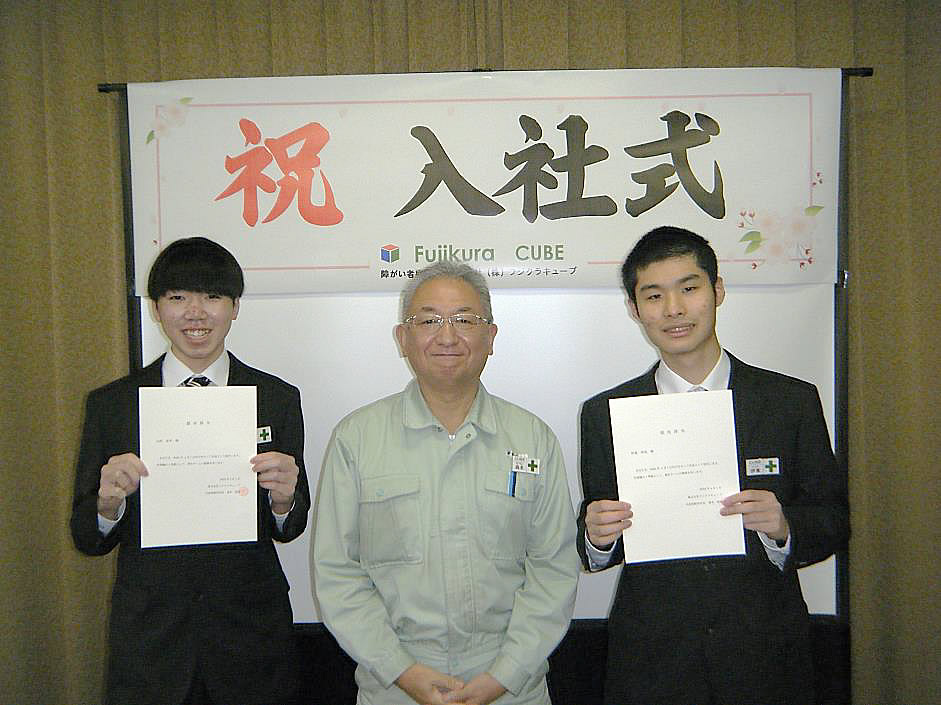 森本新社長を中心に採用辞令を手にした山村さんと伊藤さん
