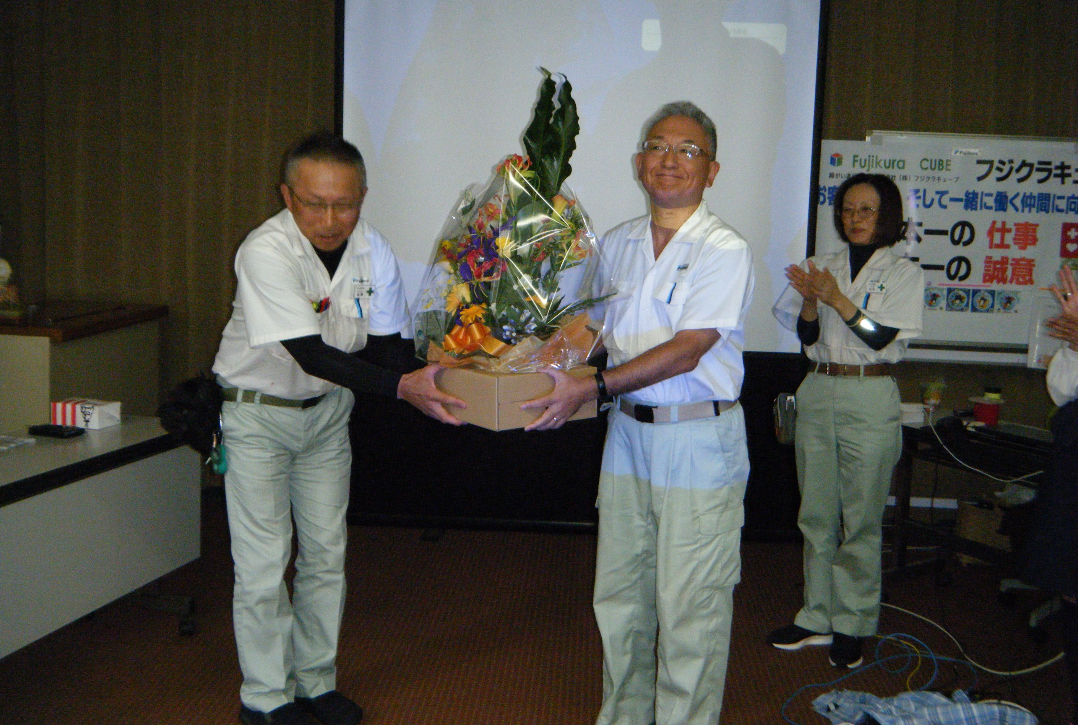 花束贈呈（左：金澤ジョブコーチ　右：森本社長）</strong>​​
